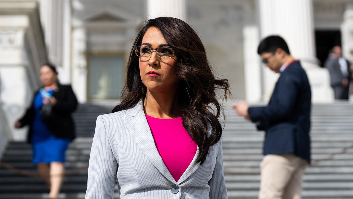 Man on his cellphone near a congresswoman.